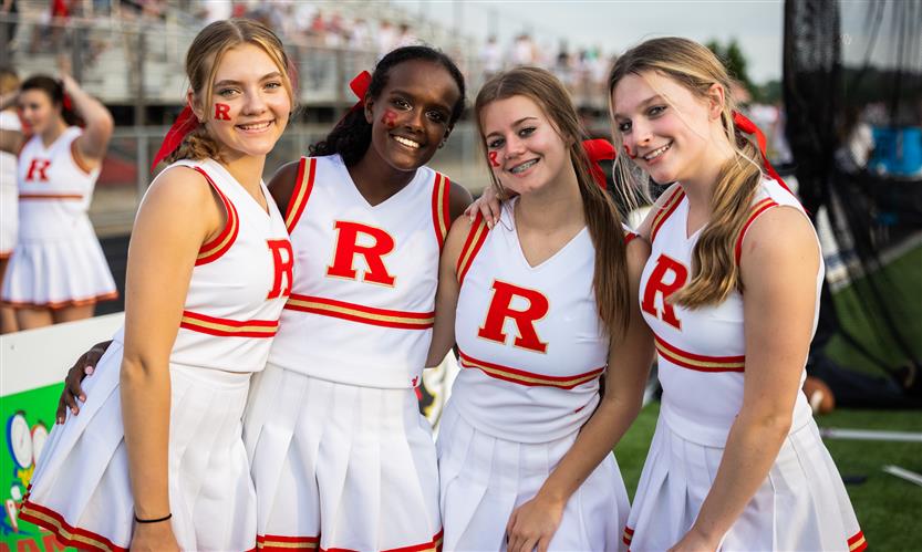 four cheerleaders smile